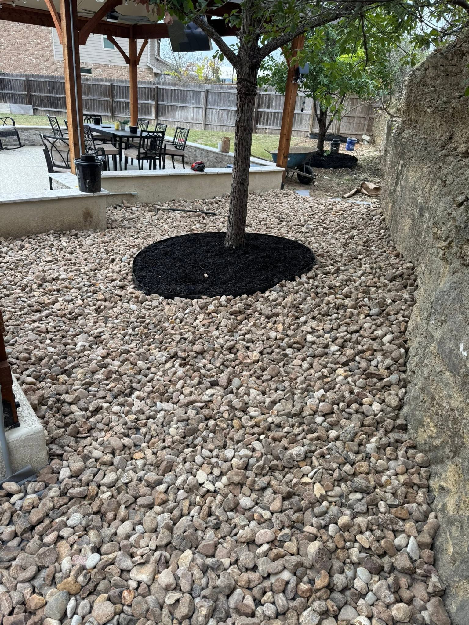 Gravel-covered landscaped path with a small tree and park seating in the background