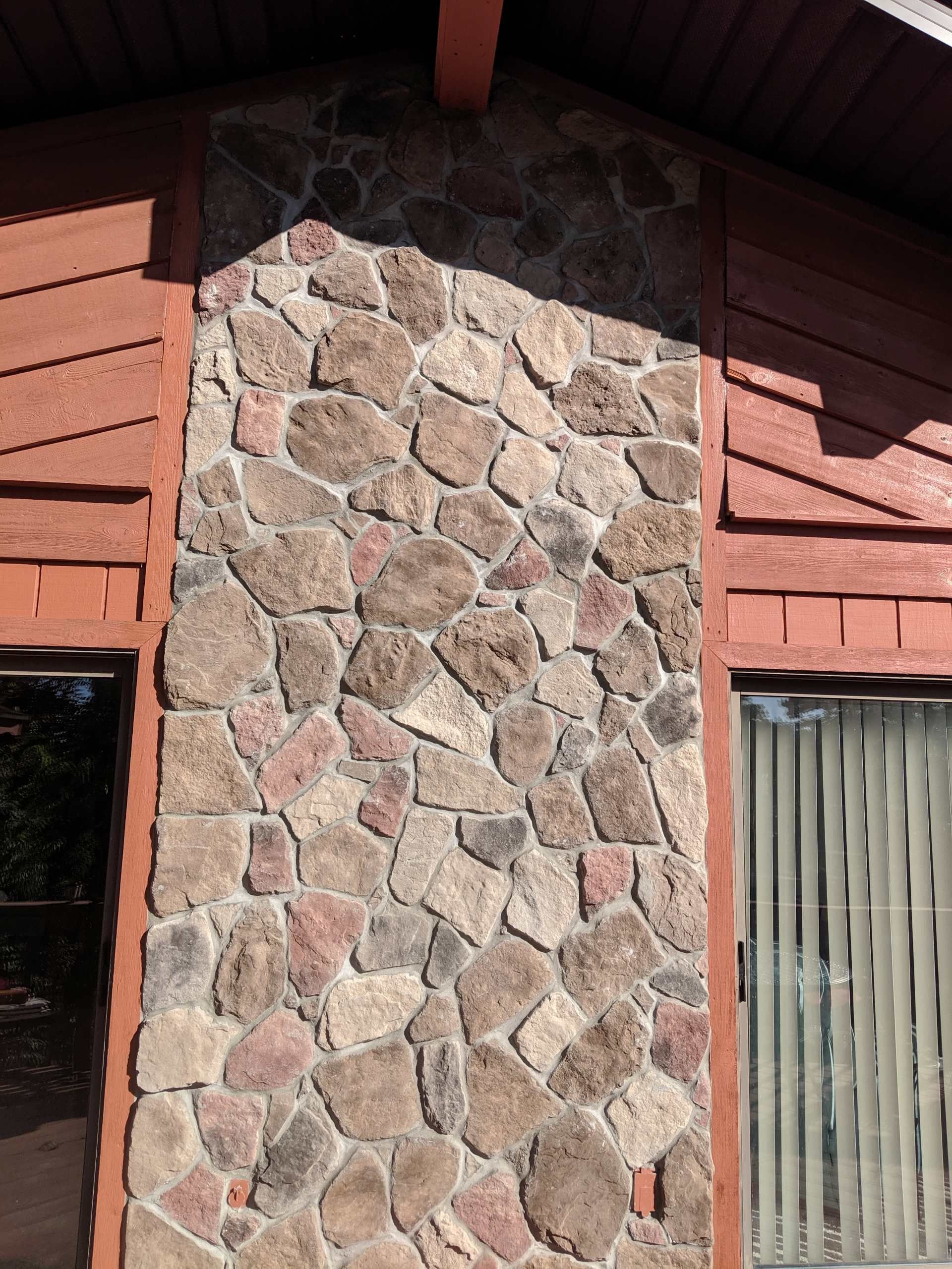 Stone facade on a building with red siding.