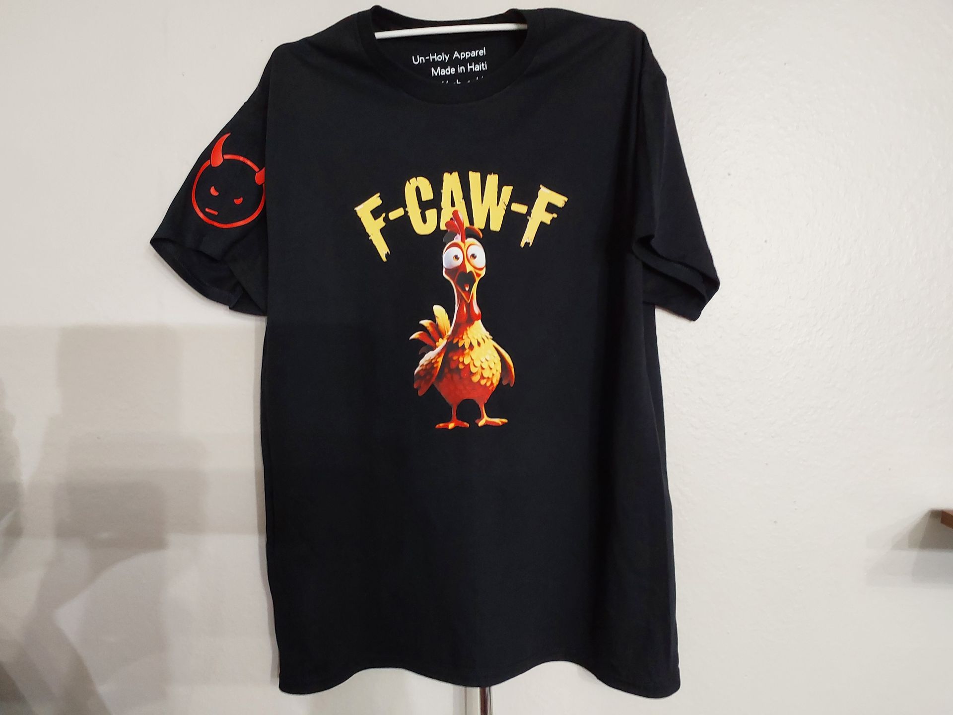 Black T-shirt with a cartoon bird and the word “F-CAW-F” printed on the front.