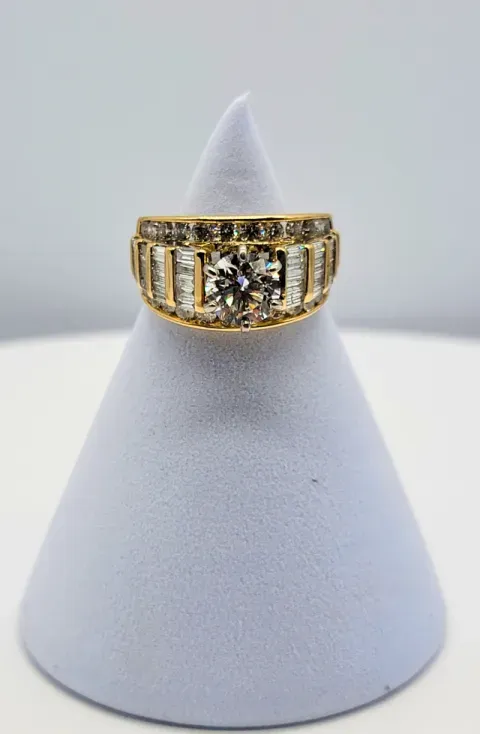 Gold ring with a large clear stone displayed on a white cone stand
