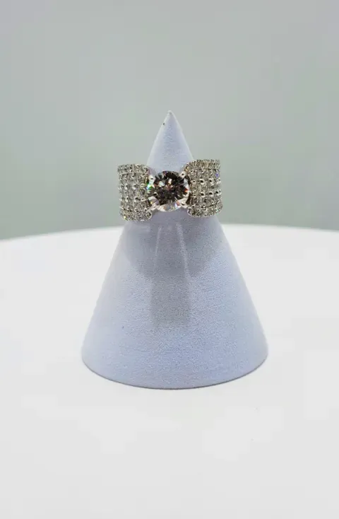 Lavender cone display stand with a glittery gold bow and jeweled center on a white surface
