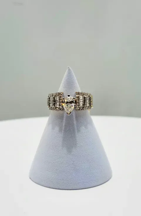 Gold and silver ring displayed on a gray velvet cone stand against a light background