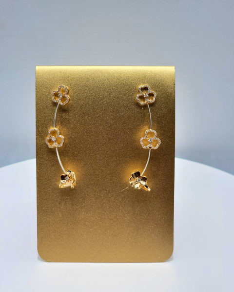Gold floral dangle earrings on a display card.