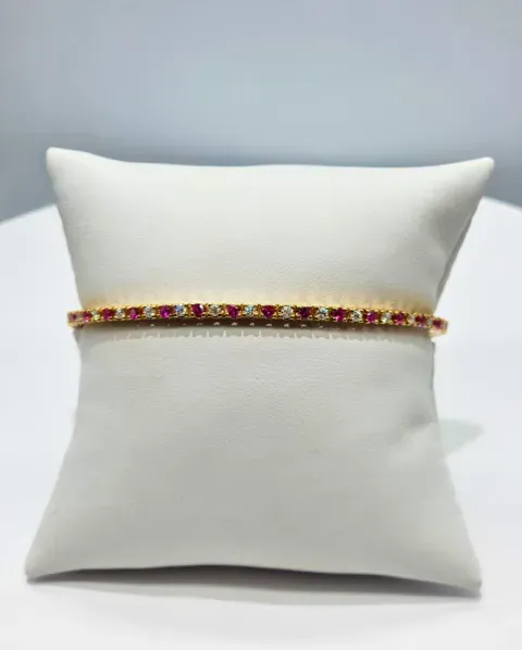 White cushion with a jeweled red and gold band across the center