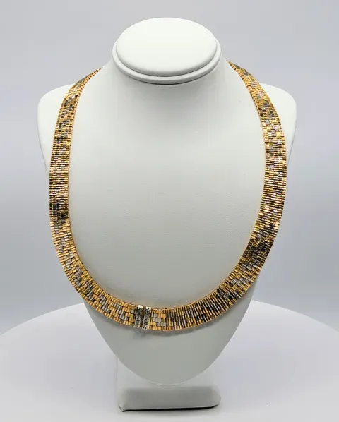 Gold-and-silver beaded necklace displayed on a white jewelry bust
