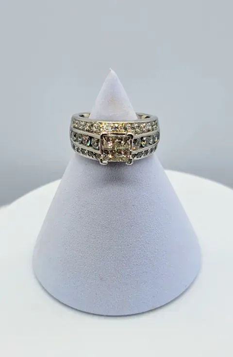 Gold and silver stacked ring with clear stones on a white display stand