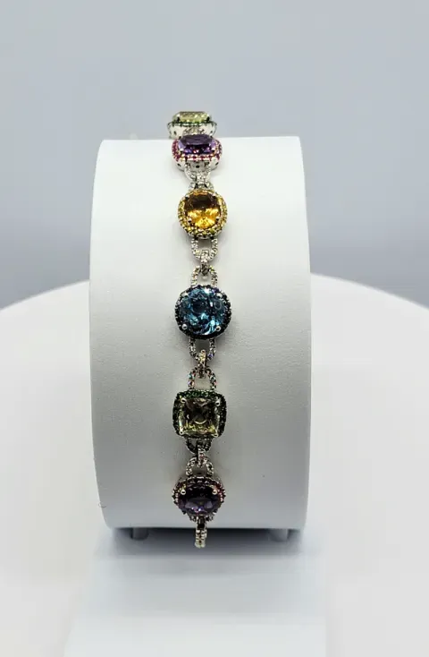 Gemstone bracelet with multicolored circular stones displayed on a white stand