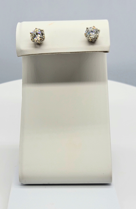 White jewelry display stand with a pair of sparkling stud earrings on top
