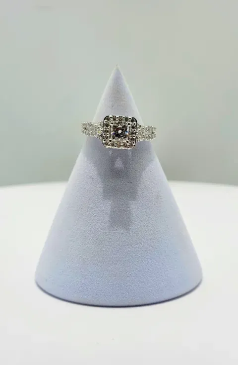 Diamond ring on a display stand against a light gray background