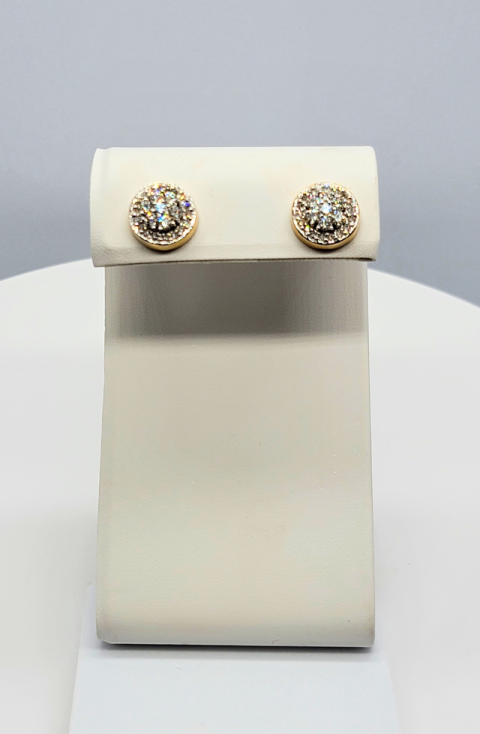 Pair of diamond stud earrings on a white display stand against a light gray background