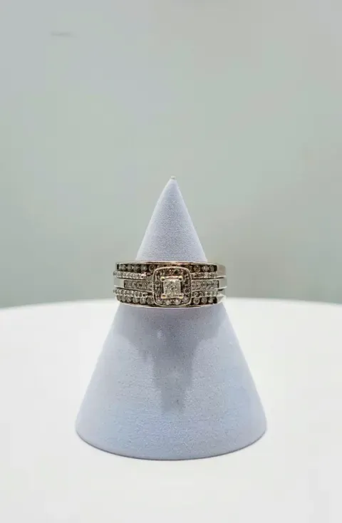 White cone jewelry display with a gold ring against a pale gray background