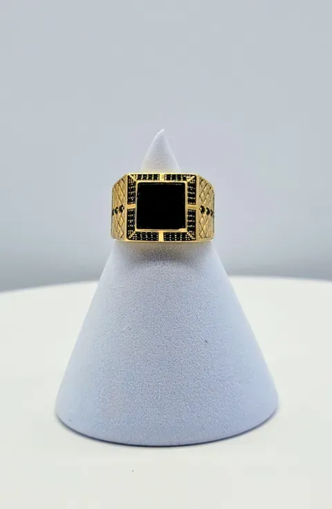 Gold ring with a black square stone displayed on a light gray cone stand