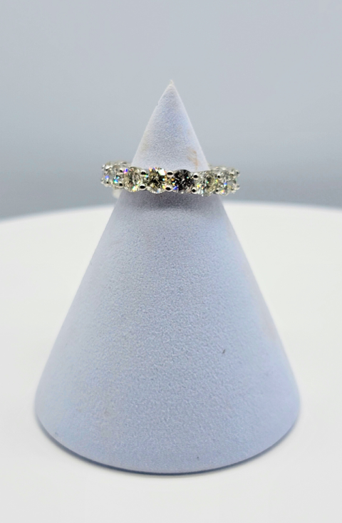 Diamond ring on a light blue cone display stand against a gray background