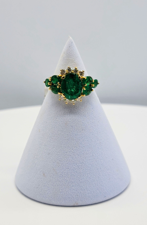 Green gemstone ring on a white display cone against a light gray background