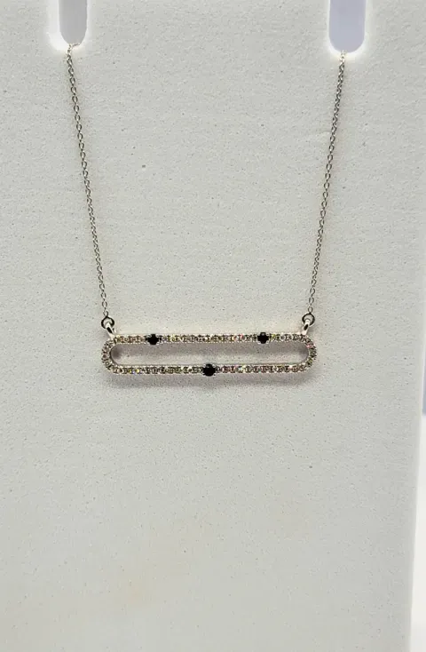 Delicate gold chain necklace with a rectangular pendant set with small stones on a white background