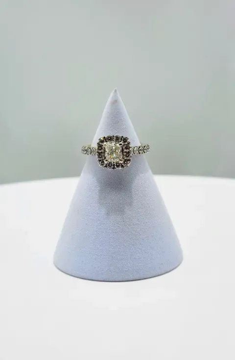 Diamond ring on a light blue display cone against a pale background