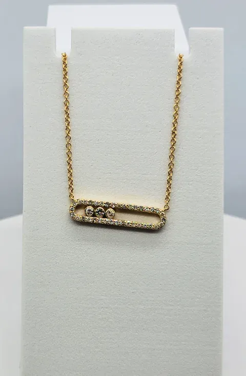 Gold chain necklace with a rectangular bar pendant on a white display stand