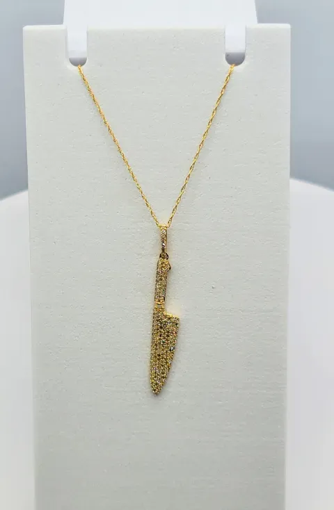 Gold necklace with a vertical pendant on a white display stand
