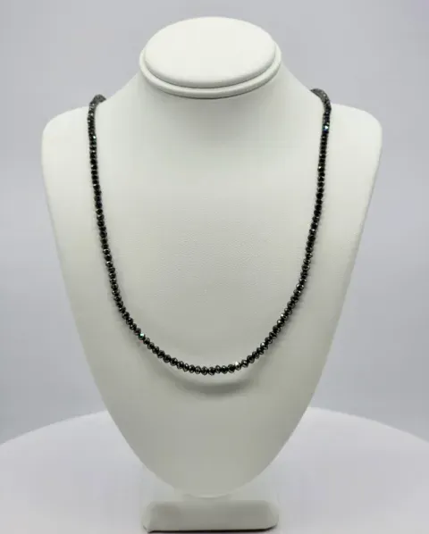 Black beaded necklace displayed on a white jewelry bust stand.