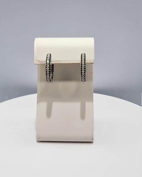 White display stand with two silver hoop earrings on a gray background
