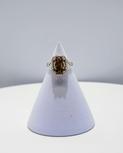 Gold ring on a white cone-shaped display stand against a light gray background