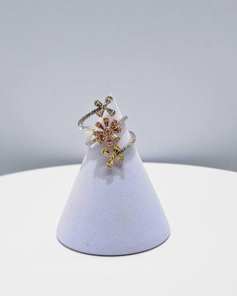 Gold floral ring displayed on a lavender cone stand against a white background