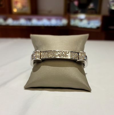 Diamond bracelet displayed on a beige cushion in a jewelry store