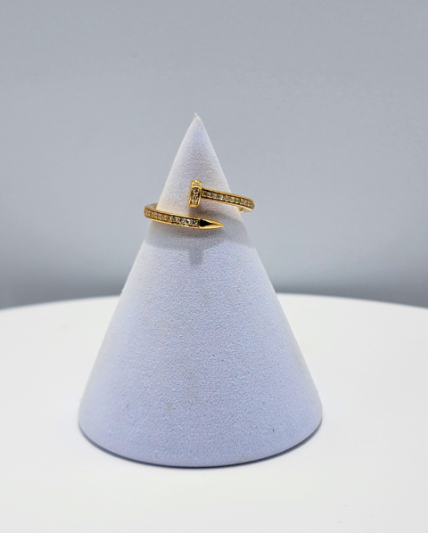 Gold ring on a white cone-shaped display against a light gray background