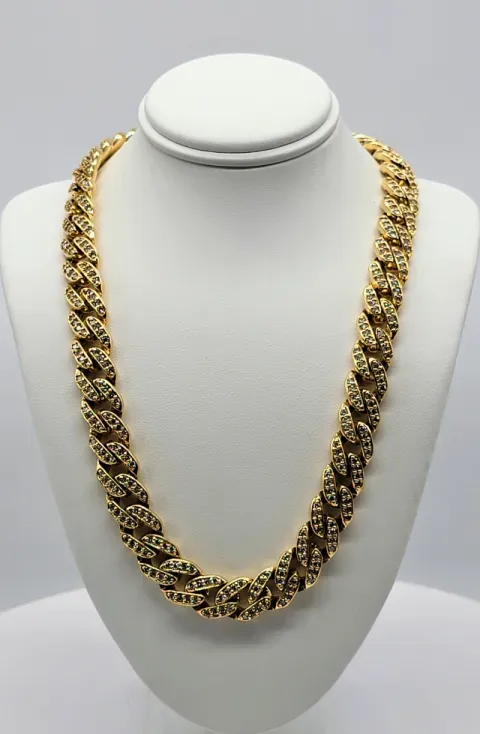 Gold chain necklace displayed on a white bust stand against a gray background