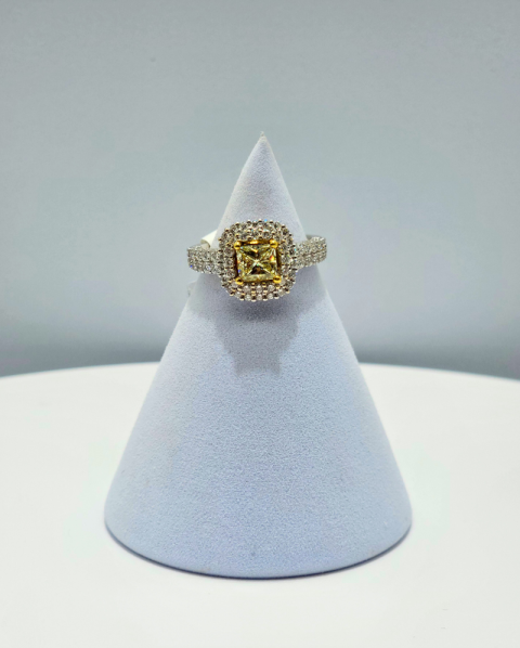 Diamond and yellow-gold ring on a white display cone against a gray background