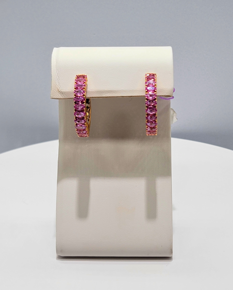 Pink gemstone hoop earrings on a display stand against a gray background