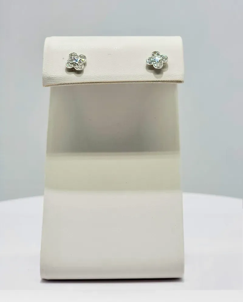 White jewelry display stand with a pair of small crystal stud earrings on top
