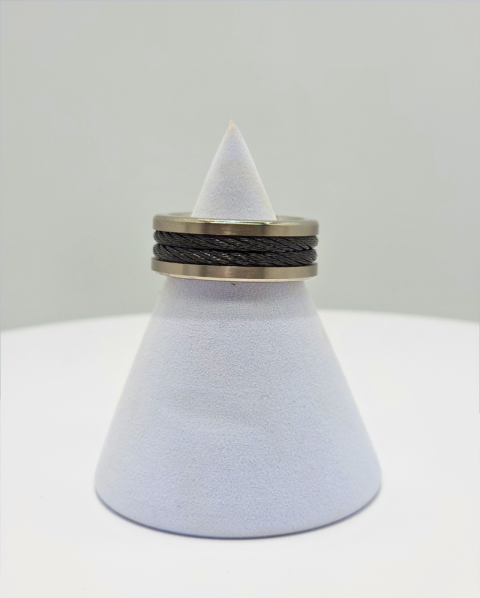 White cone-shaped object with stacked black and beige rings around the top on a light background