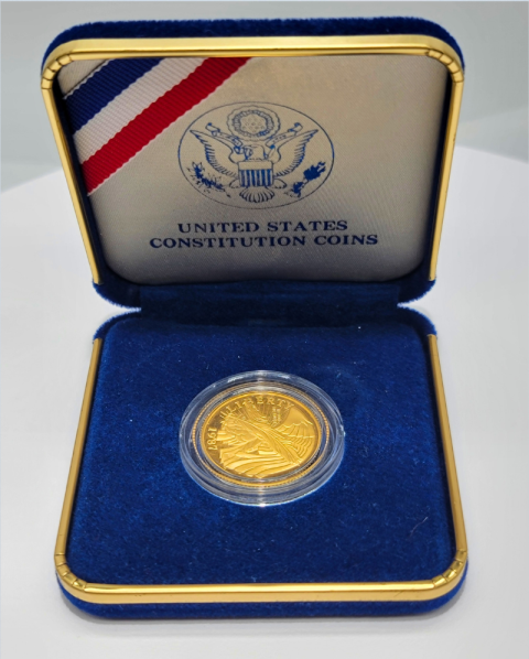 Blue coin case with a gold United States Constitution coin inside