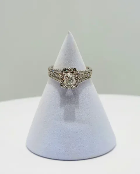 Diamond ring on a white display stand against a light background