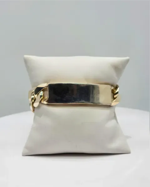 White cushion bracelet display with a gold bangle and dark center panel
