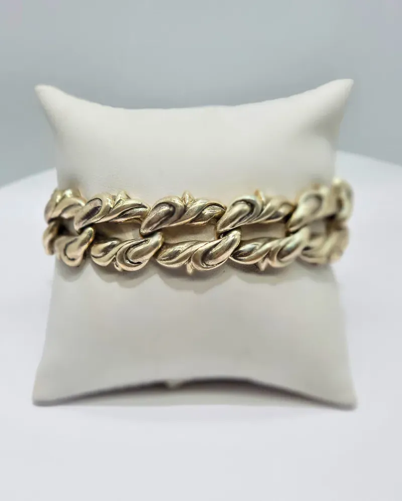 Gold chain bracelet on a white display pillow
