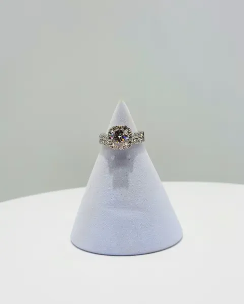 Diamond ring on a white cone display against a light gray background