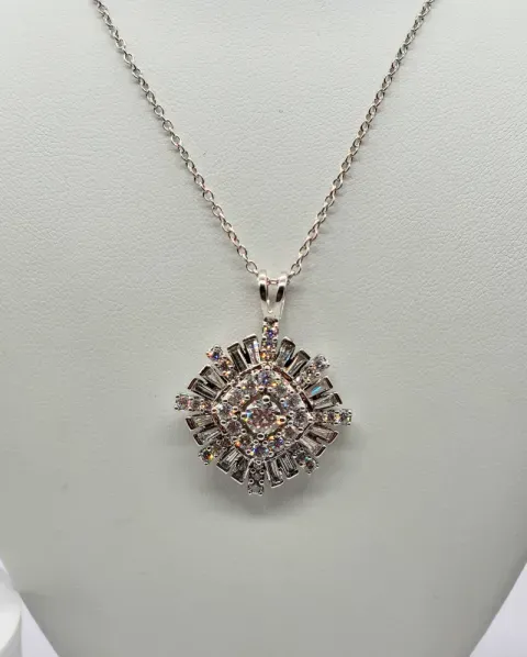 Silver necklace with a round, diamond-like pendant on a light gray display stand