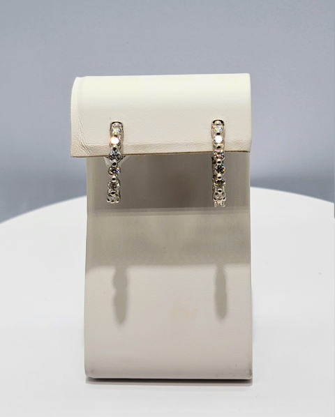 White cylindrical handbag with silver chain straps on a light background