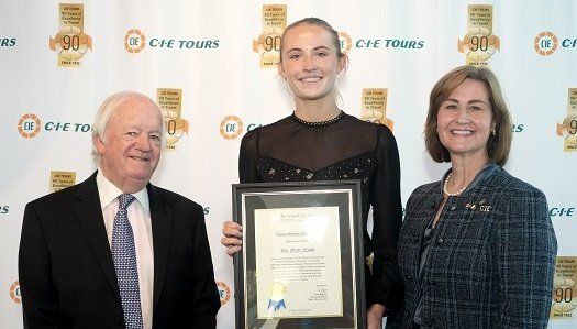 two board members and scholarship student holding certificate