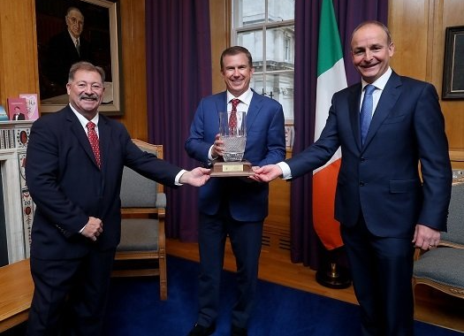 two. board members with the winner of the award for achievement
