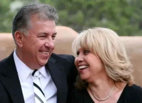 Smiling couple in formal wear laughing outdoors at an event