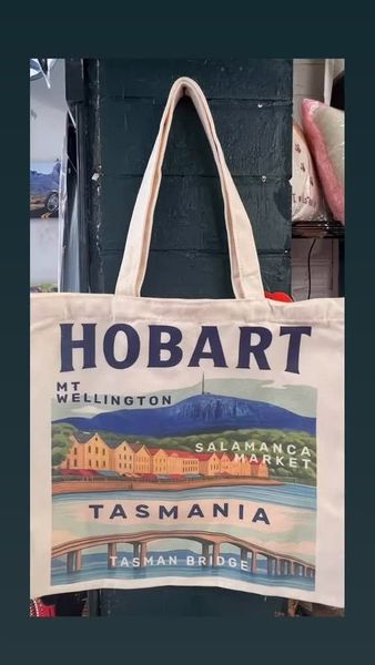Canvas tote bag with “HOBART” and Tasmania scenery illustration hanging on a wall