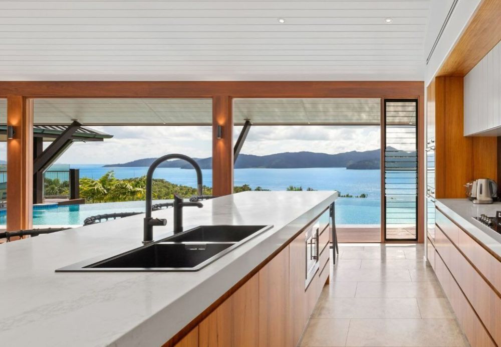 A Kitchen with A Sink and A View of The Ocean — North Queensland Glass & Glazing In Cannonvale, QLD