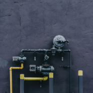 A bunch of pipes are attached to a wall.