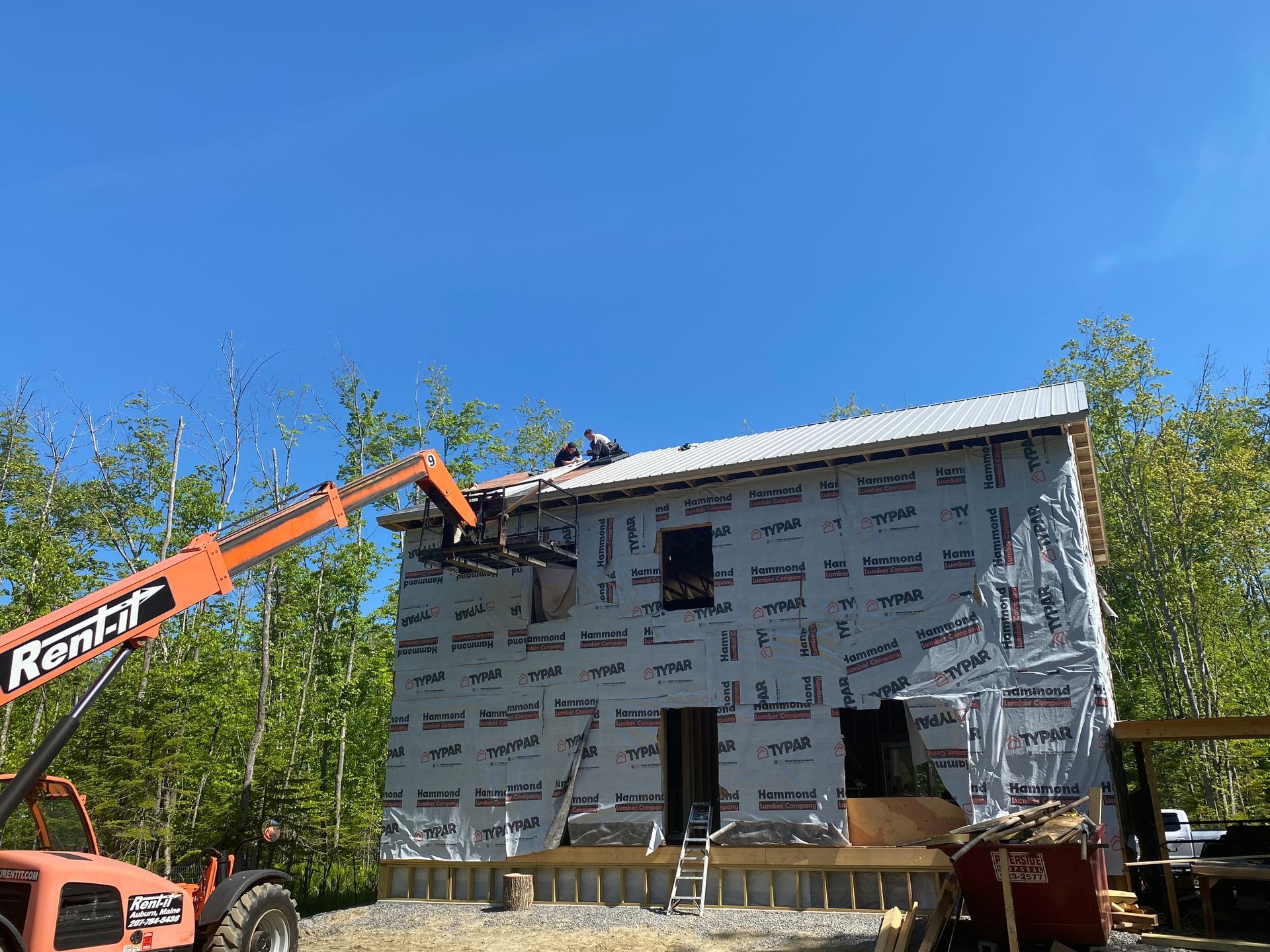 a rental forklift is lifting a roof of a building
