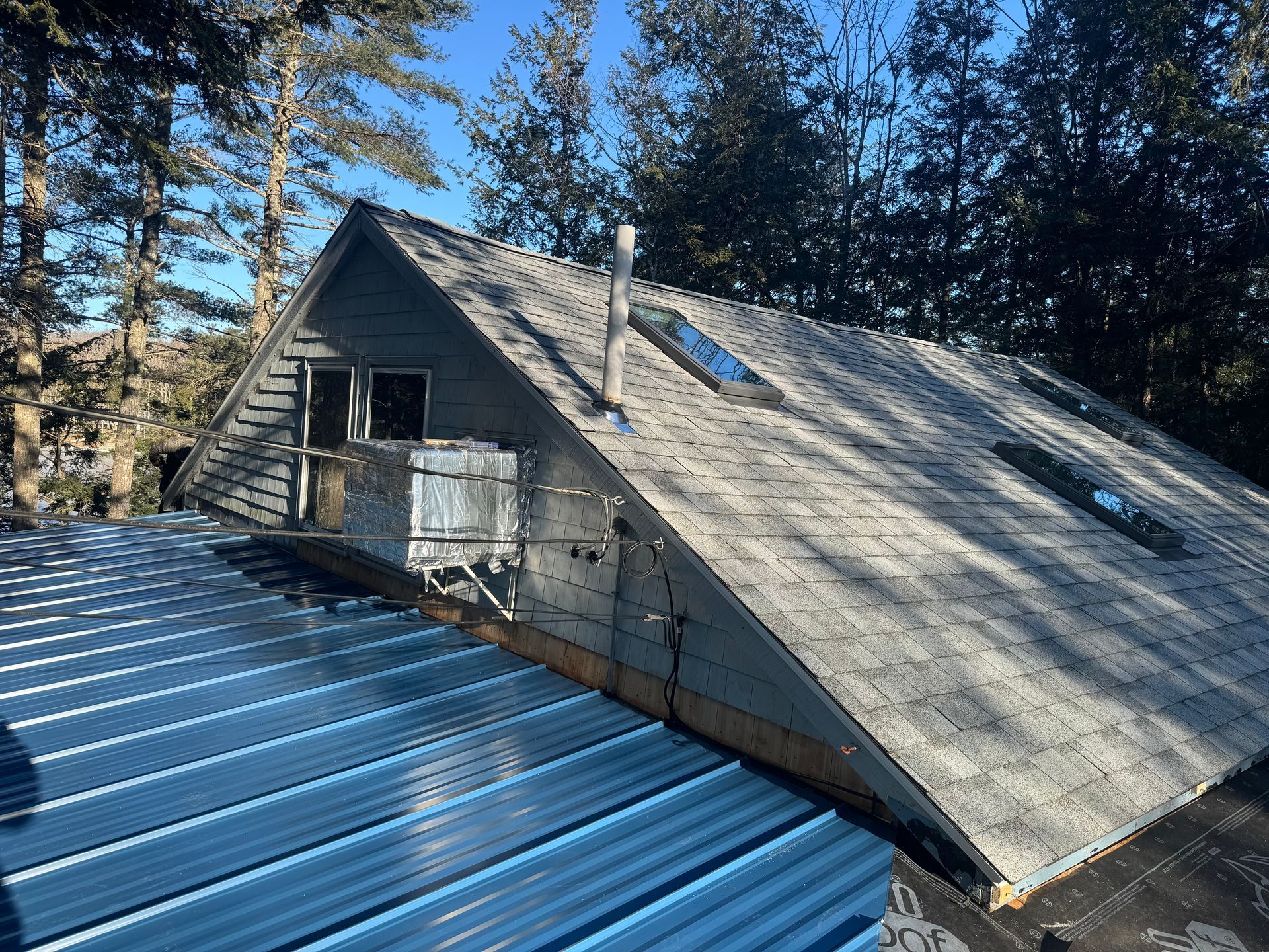 A house with a metal roof and a skylight on the roof.