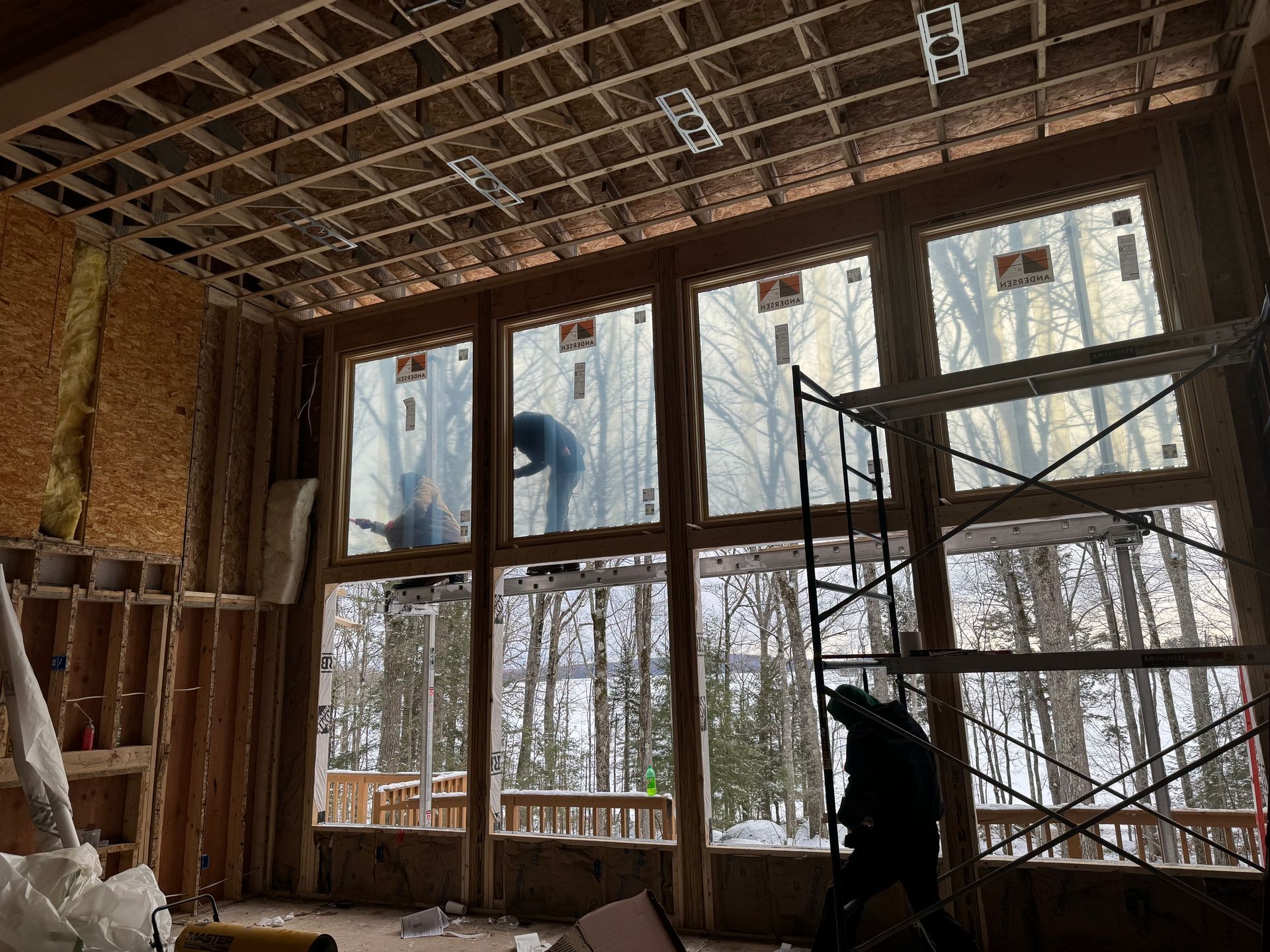 the inside of a home being renovated with tall walls and andersen windows