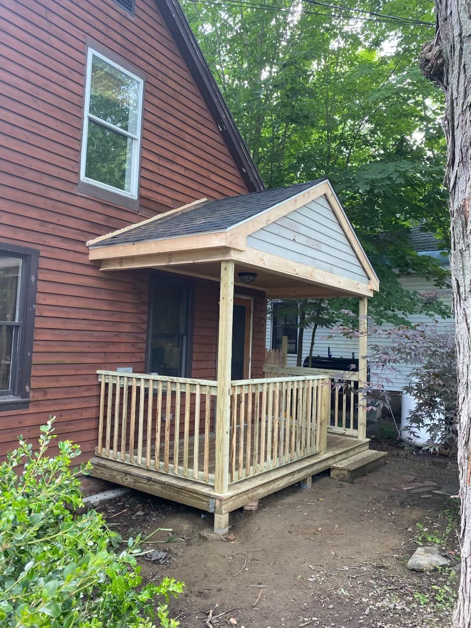 A wooden porch is being built on the side of a house.